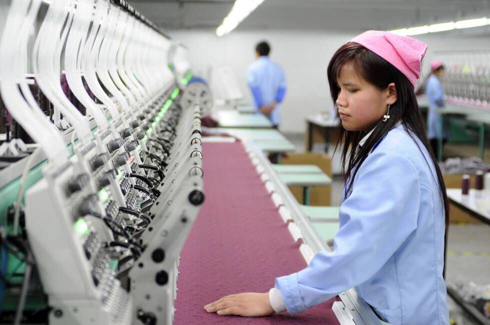 Una trabajadora toca la tela de la fábrica textil automatizada de Antex en Hangzhou.
