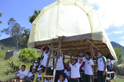 Estudiantes atienden una explicación a la sombra de un deshidratador.