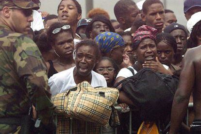 Un grupo de personas trata de subir a los autobuses que desalojan Nueva Orleans.
