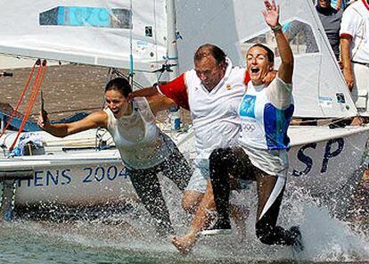 Natalia Vía-Dufresne (a la derecha) y Sandra Azón se lanzan al agua junto al director del equipo olímpico español, José María Benavides, tras conquistar la medalla de plata en la clase <i>470</i>.