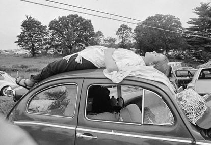 Una joven toma una siesta en la parte superior de su automóvil, el 16 de agosto, en la vía hacia el festival Woodstock. El festival se hizo leyenda también por su memorable caos: aforo desbordadísimo, coches abandonados en el atasco, artistas llegando en helicóptero, baños en el barro y Jimi Hendrix distorsionando el himno de EE UU ya amanecido el lunes.