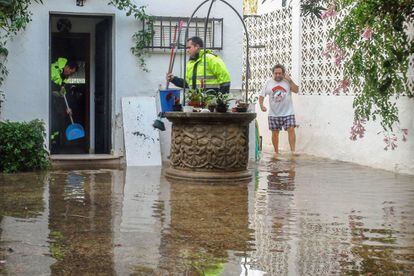 Uns veïns del Passeig Marítim de Conil de la Frontera (Cadis) netegen casa seva després de les pluges que han provocat una trentena d'incidències a la província de Cadis.