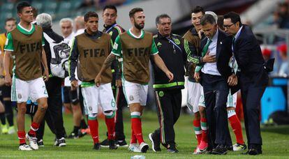 Juan Carlos Osorio (d) es detenido por Lozano y su cuerpo técnico al final del partido