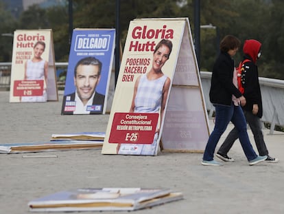 Un par de transeúntes junto a propaganda electoral de Consejeros Constitucionales, el 26 de abril de 2023, en Santiago (Chile).