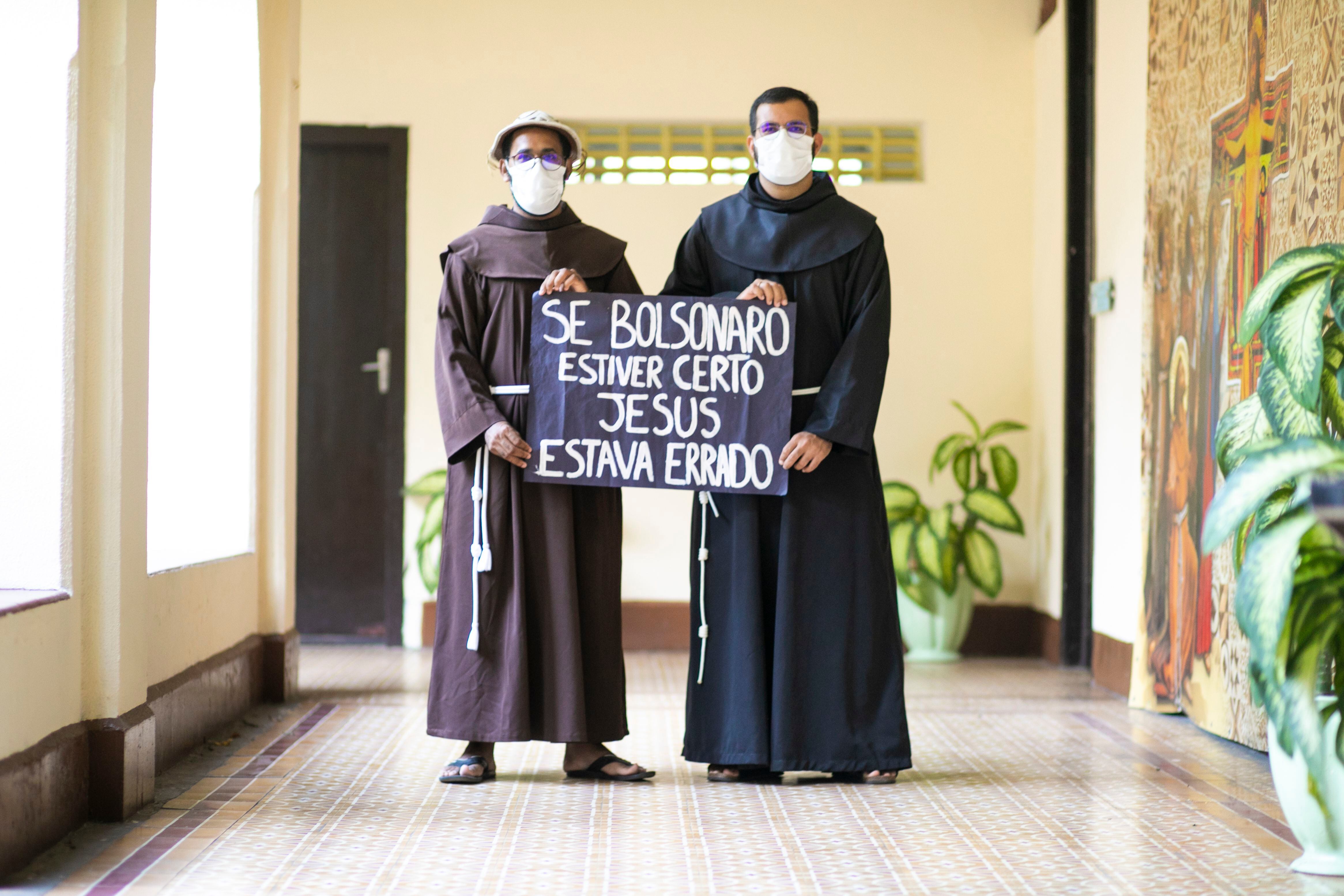 Lorraine y José Hélio sostienen una pancarta en rechazo a Bolsonaro.