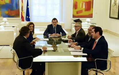 El presidente del Gobierno, Mariano Rajoy, en el centro de la mesa, en una reunión en La Moncloa, con la ministra de Empleo, y los líderes de los agentes sociales