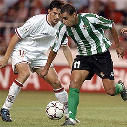 Denilson del Real Betis pelea un balón con Marti del Sevilla en el estadio Ramón Sanchez Pizjuán.