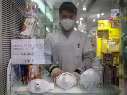 Un treballador mostra diversos tipus de mascaretes a la venda a la seva farmàcia.