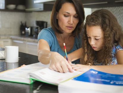 Una madre ayuda a su hija con sus estudios.
