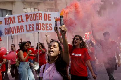 Varios personas portan bengalas durante la manifestación convocada por los sindicatos bajo el lema 'Subir salarios, bajar precios y repartir beneficios', en Valencia.