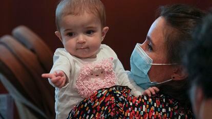 La pequeña Emma, de 13 meses, en brazos de su madre, Ana, hoy en el hospital público madrileño de La Paz.
