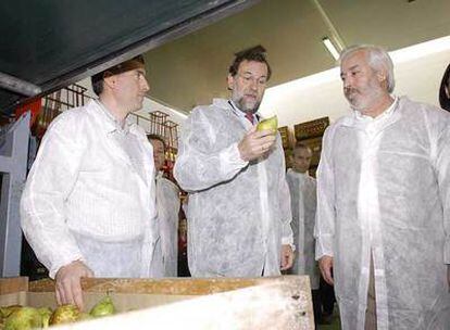 El líder del PP, Mariano Rajoy, acompañado de los gerentes de la cooperativa Fruitsa Cat, durante su visita a las instalaciones de la empresa ubicada en el municipio leridano de Bellvis.