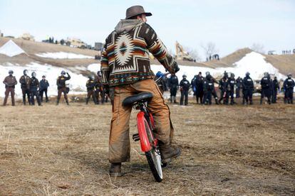 Un hombre observa el avance de las fuerzas de seguridad en el campamento contra el oleoducto Dakota Access.
