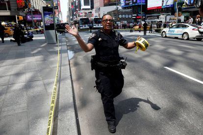 Un agente de policía hace señales a la gente a regresar a Times Square, después de que un vehículo de golpease a varios peatones en una acera en Times Square.