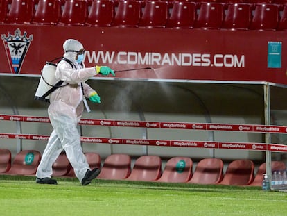 Un operario desinfecta los banquillos del estadio Municipal de Anduva.