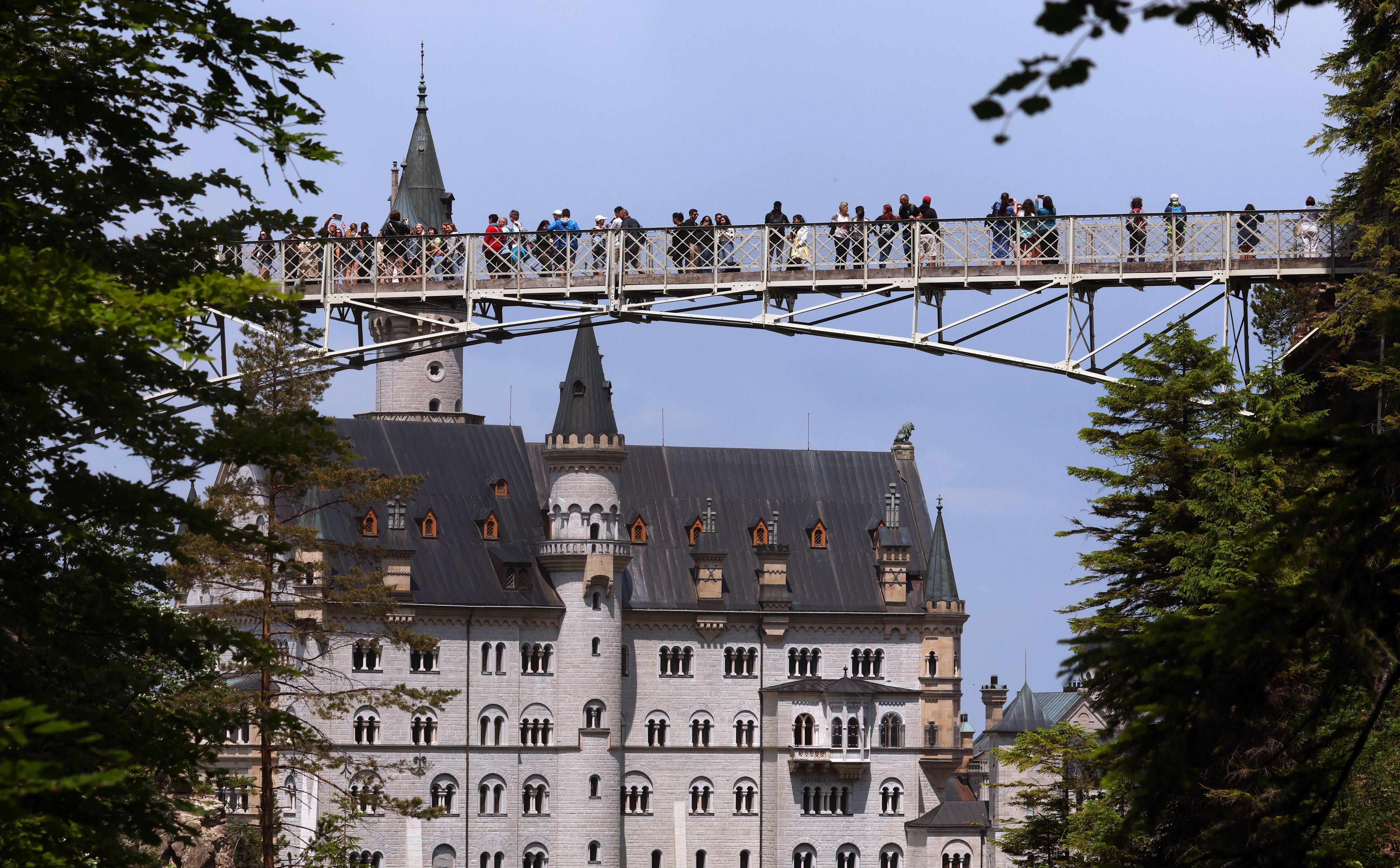 Varios visitantantes sobre el puente Marienbrücke, frente al castillo de Neuschwanstein (Baviera).