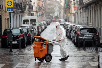 Un operario recoge basura, hoy en Valencia, durante el decimoséptimo día del estado de alarma.