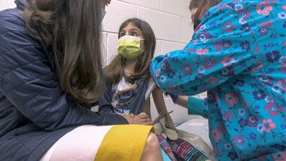 Alejandra Gerardo, de nueve años, mira a su madre mientras la vacunan contra la covid en el hospital universitario de la Universidad de Duke. Alejandra y su hermana gemela Marisol son las primeras niñas en recibir la vacuna de Pfizer en EE UU.