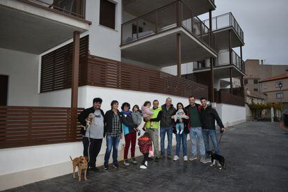 Algunos de los nuevos vecinos de Letur (Albacete) junto a los pisos donde viven.