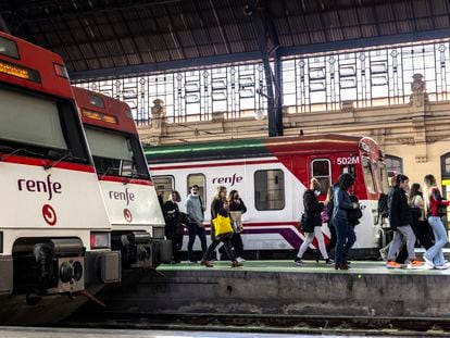 Varias personas pasaban el lunes junto a trenes de cercanías en la Estación del Norte de Valencia.