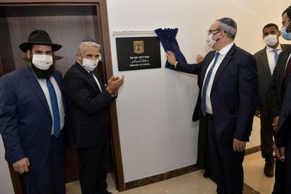 El ministro israelí de Exteriores, Yair Lapid, aplaude ante la placa que marca la inauguración de la Embajada de su país en Emiratos Árabes.