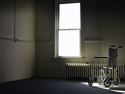 En la imagen, una silla de ruedas en una habitaci&oacute;n vac&iacute;a.