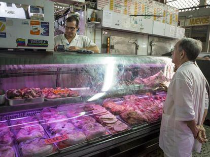 Un hombre pregunta el jueves el precio de la carne en un mercado popular de Caracas.