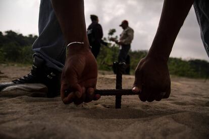 Un hombre entierra una varilla para buscar cuerpos en Colinas de Santa Fe, Veracruz.