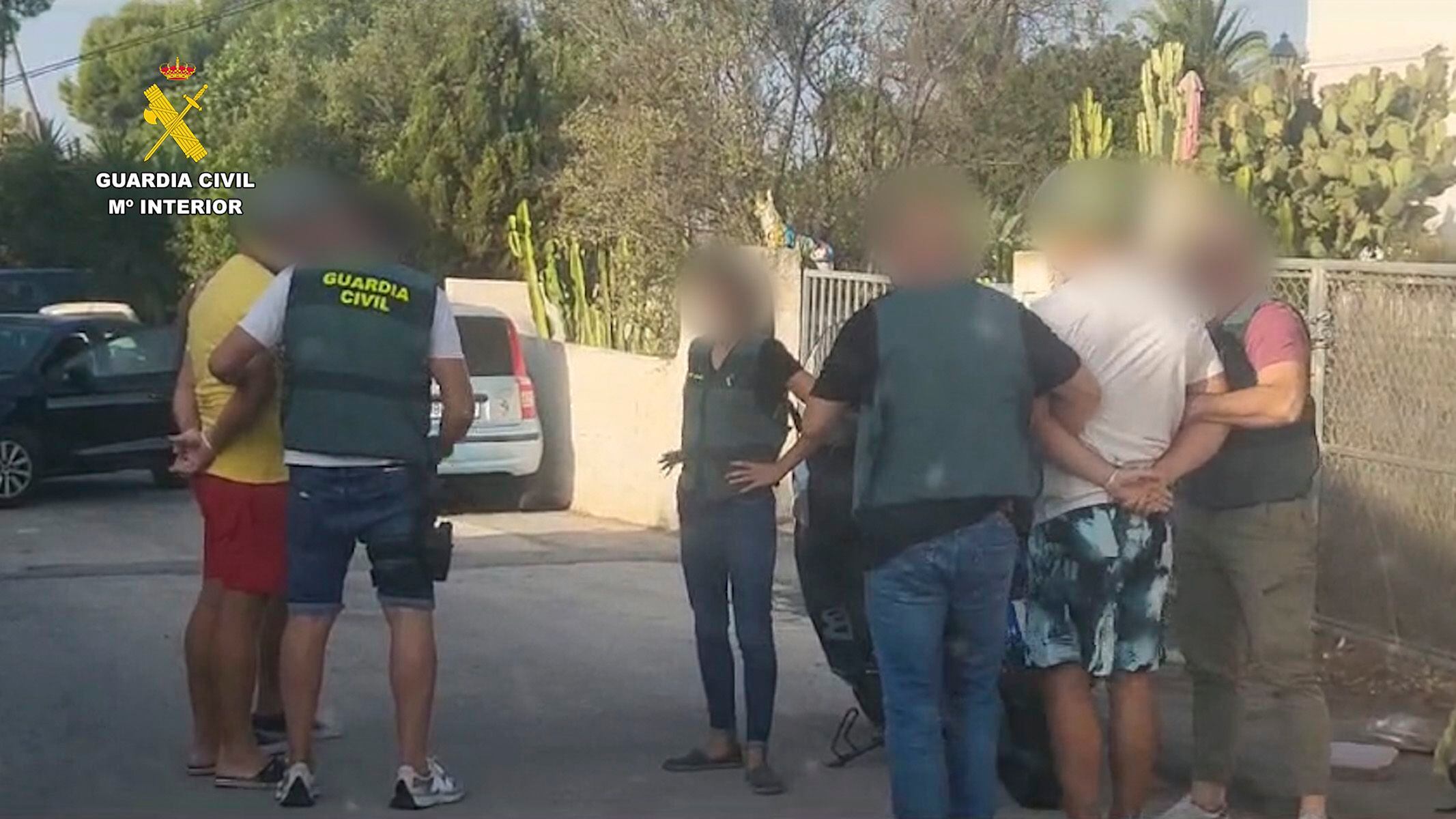 Varios guardias civiles junto a uno de los tres fugitivos detenidos.