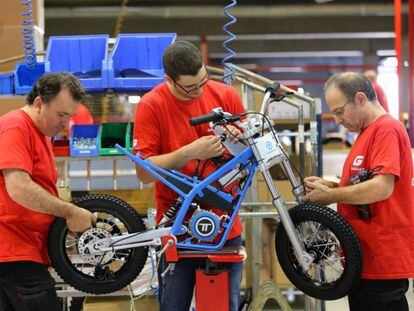 Operaris de la fàbrica de Torrot a Salt assemblen una moto.