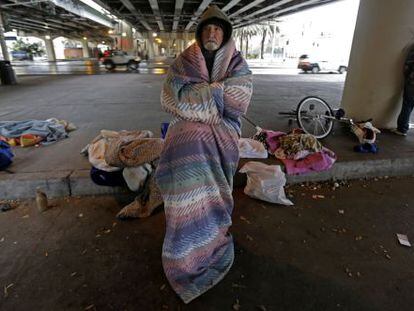 Un sin techo se arropa bajo un puerte en Nueva Orleans.