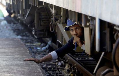 Un inmigrante en la estación de Gevgelija (Macedonia) intenta colarse en un tren para dirigirse a Serbia.