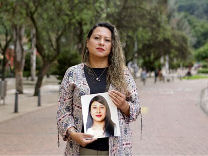 Mariluz Beltrán sostiene una foto de su hermana Yudi Angélica, víctima de feminicidio, en una imagen tomada en el centro de Bogotá, el 6 de mayo de 2023.