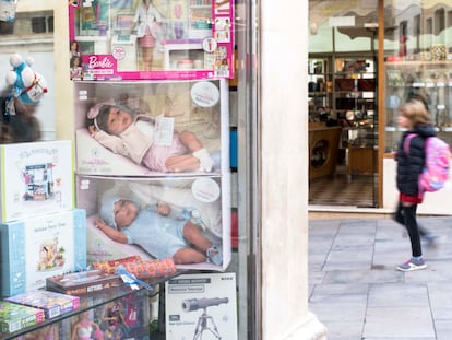 MAHÓN (ESPAÑA), 30/11/2022.- Una menor camina por la calle junto al escaparate de una tienda de juguetes, este miércoles en el centro histórico de Mahón, Menorca. La publicidad en España tendrá que ser mixta y desde mañana no se podrán ver en televisión anuncios de nueva producción de muñecas en brazos solo de niñas o a estas jugando a las "cocinitas", según el código deontológico sobre la publicidad no sexista de juguetes que entrará en vigor el 1 de diciembre. EFE/ David Arquimbau Sintes
