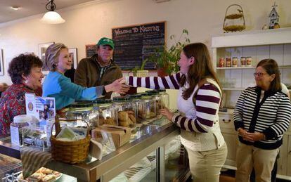 Hillary Clinton saluda a los trabajadores de una pastelería en New Hampshire.
