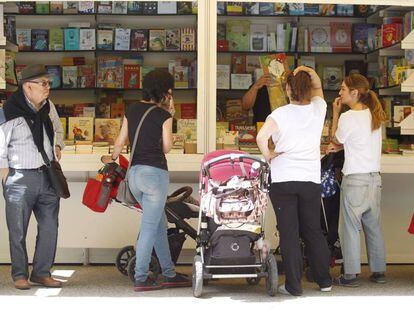 Varias personas visitan una caseta de la Feria del Libro.