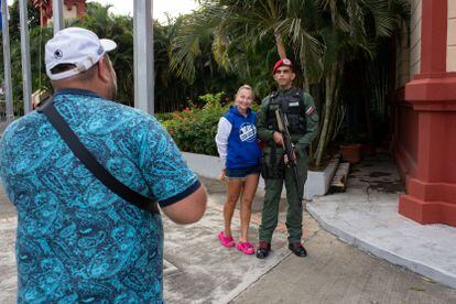 Una turista rusa se fotografía junto a un militar venezolano que hace guardia afuera del mausoleo del expresidente Hugo Chávez, en Caracas. 