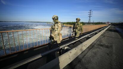 FILE - Russian troops patrol an area at the Kakhovka Hydroelectric Station, a run-of-river power plant on the Dnieper River in Kherson region, south Ukraine, on May 20, 2022. Moscow has warned that Ukraine may try to attack the dam at the Kakhovka hydroelectric power plant about 50 kilometers (30 miles) upstream and flood broad areas, including the city of Kherson. Ukrainian forces pressing an offensive in the south have zeroed in on Kherson, a provincial capital that has been under Russian control since the early days of the invasion. This photo was taken during a trip organized by the Russian Ministry of Defense. (AP Photo, File)