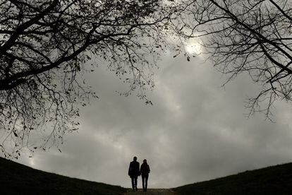 Una pareja pasea bajo un cielo cubierto de nubes, por el parque de la Ciudadela en Pamplona, España.