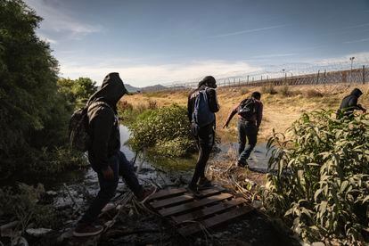 Unos migrantes se aproximan a la frontera. 