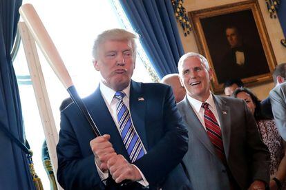 El vicepresidente Mike Pence sonríe mientras el presidente Donald Trump sostiene un bate de béisbol durante una muestra de productos 'Made in America' en la Casa Blanca, el 17 de julio de 2017.