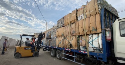 Empleados de Sinba descargan desechos plásticos de un camión para iniciar su proceso de recuperación y reutilización.