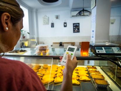 Una empleada de una pastelería ajusta la temperatura del establecimiento a la nueva normativa.