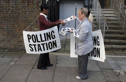 Trabajadoras de un colegio electoral colocan señales fuera de un centro de votación en Londres.