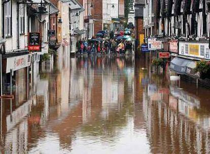 Un grupo de personas contempla las inundaciones en Droitwich, en el centro de Inglaterra.