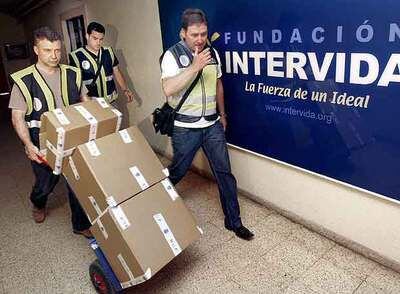 Agentes del Cuerpo Nacional de Policía abandonan la sede de la fundación en Barcelona al finalizar un registro.