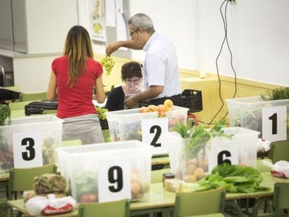 Un grupo de consumidores reparte los alimentos en las cestas durante el turno semanal de una cooperativa.