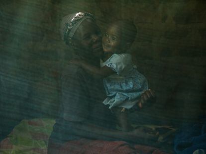 Margaret Ayuma y Julia Kulema bajo la mosquitera de su cama, en su vivienda en Musitinyi, Kenia. Margaret ha sido de los primeros niños en recibir la vacuna contra la malaria.