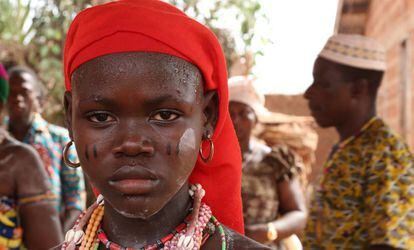 Una niña con marcas tribales en las mejillas.