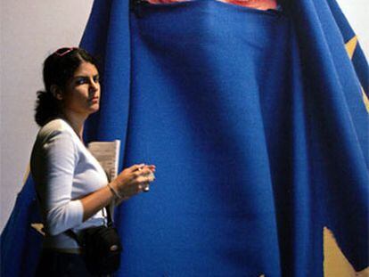 Una mujer pasa ante un mural que representa a una ciudadana turca velada con la bandera europea.
